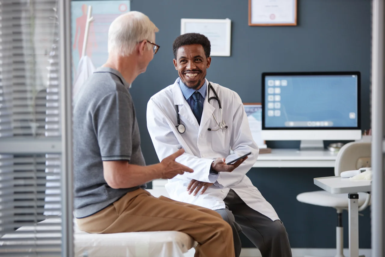 A doctor talking happily with his patient.